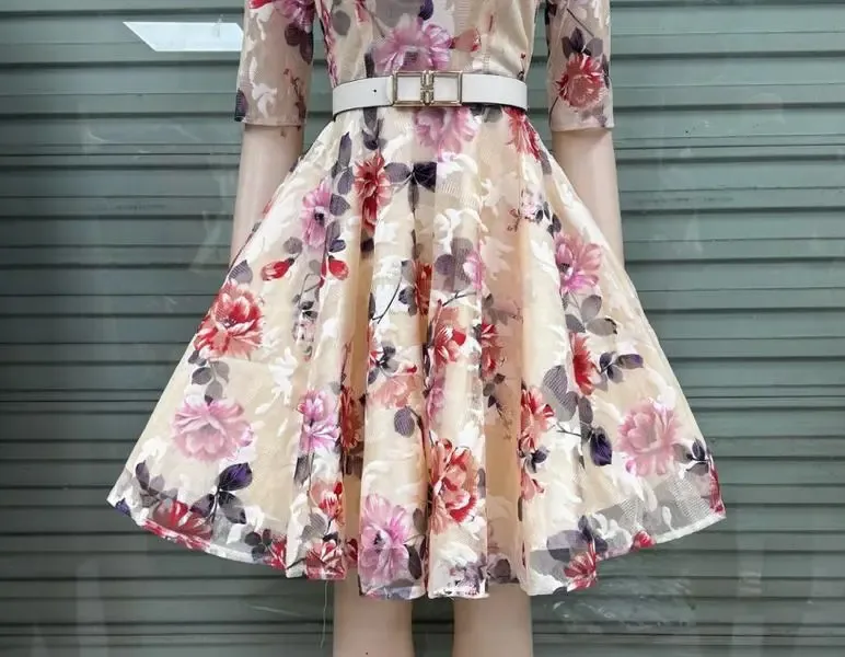 A floral knee-length skater dress with 3/4 sleeves.